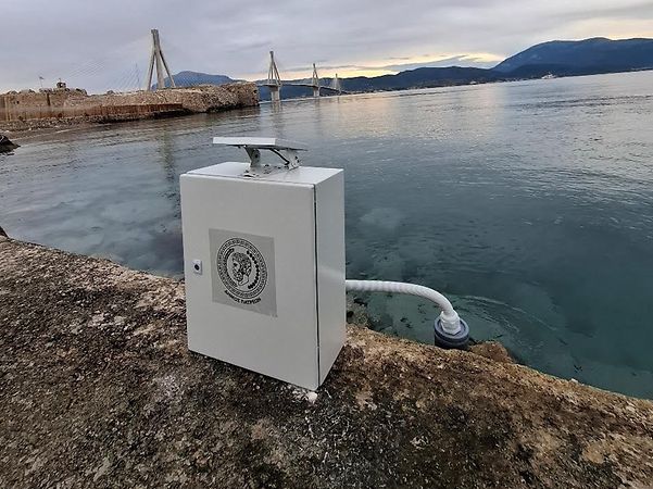 A monitoring station on the riverbank for monitoring water quality, with a bridge in the background.