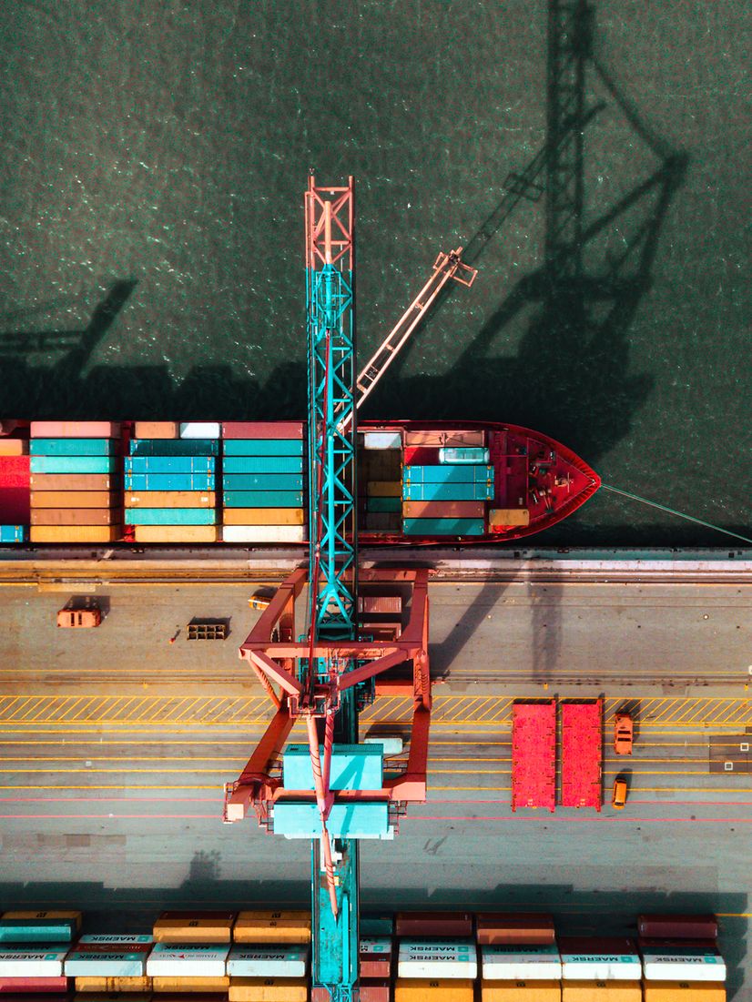 Frachtschiff im Hafen beim Beladen von Containern, unterstützt durch Telekom IoT für Nachverfolgung in Echtzeit