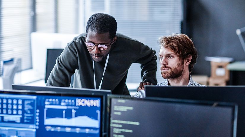 Zwei Personen im Büro analysieren IoT-Daten am Computer 