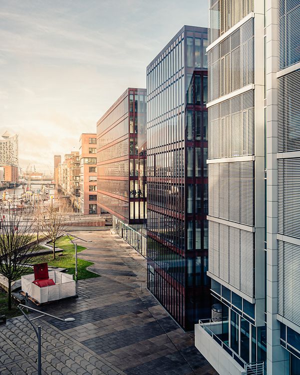 Moderne Gebäude mit Glasfassaden und Grünflächen symbolisieren die Zukunft der smarten Gebäudeverwaltung