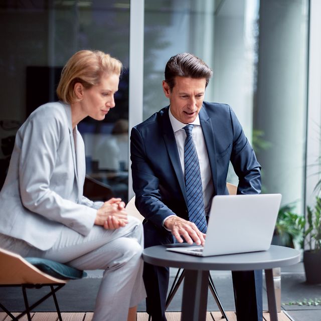 Zwei Personen im modernen Büro schauen am Laptop die Referenzen der Telekom IoT an.