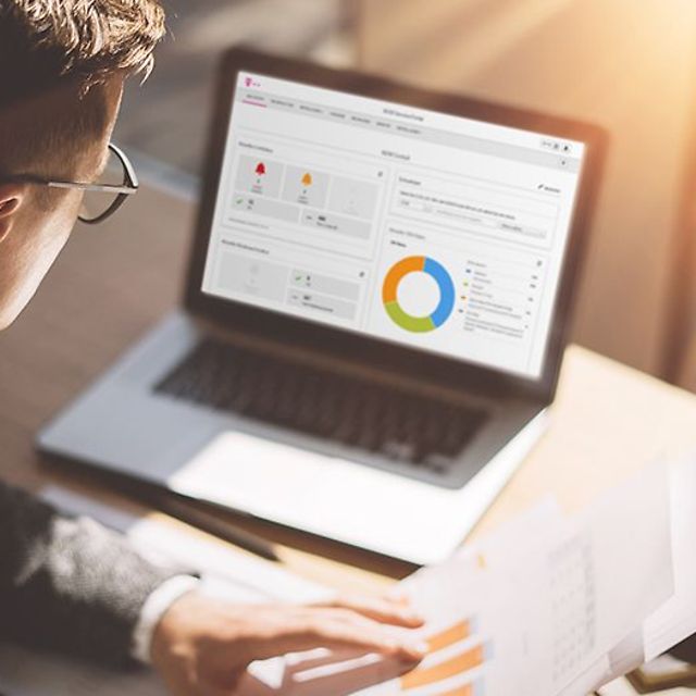 Eine Person betrachtet auf einem Laptop eine Datenanalyse mit Diagrammen zum IoT M2M Service Portal.