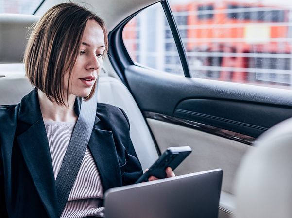 Eine Geschäftsfrau sitzt in einem Auto mit HotSpot Drive