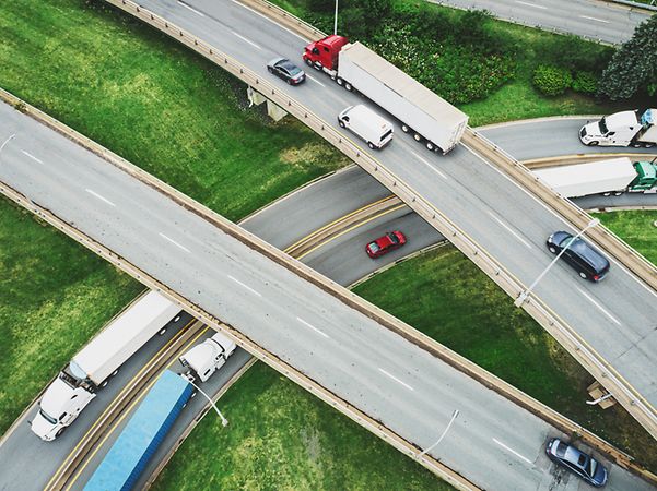 Drone shot: a motorway junction from above with some trucks and cars