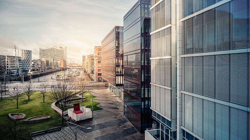 Modern buildings with glass facades and green spaces symbolize the future of smart building management