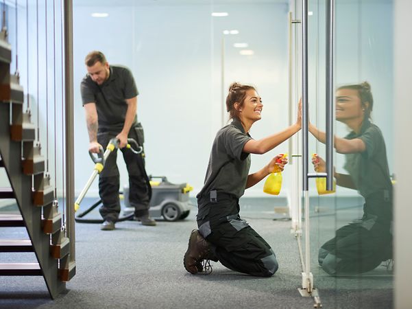 Employees of the cleaning company are cleaning a hallway in the office building