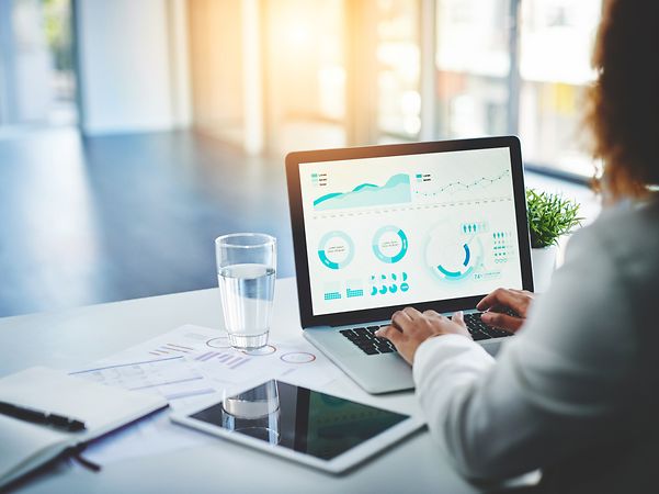 Woman sitting at desk and typing on a laptop keyboard.
