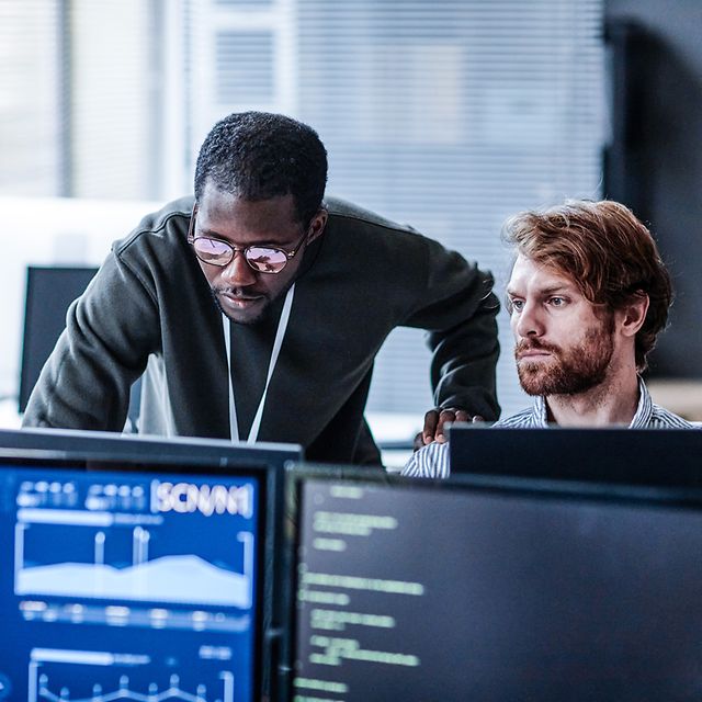 Two people in the office analyze IoT data on the computer