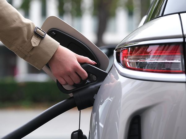 Hand plugging in an electric vehicle charging cable.