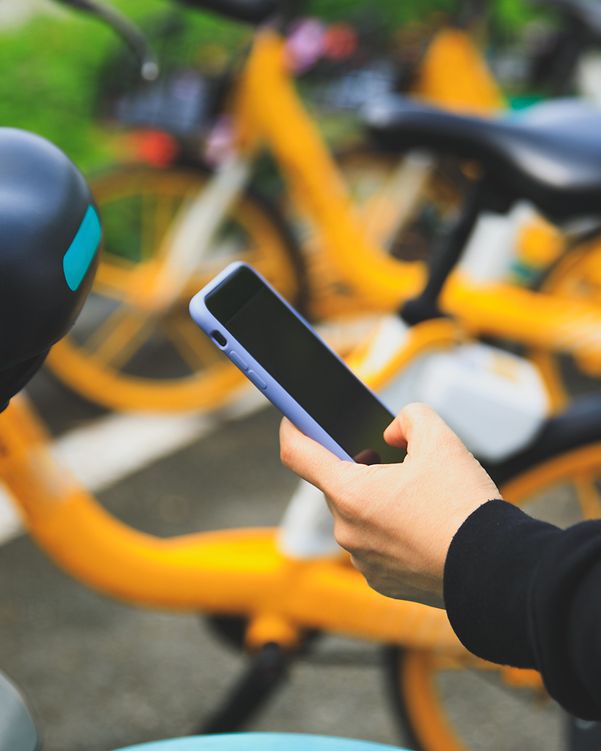 Person unlocking a rental bike using a smartphone app.